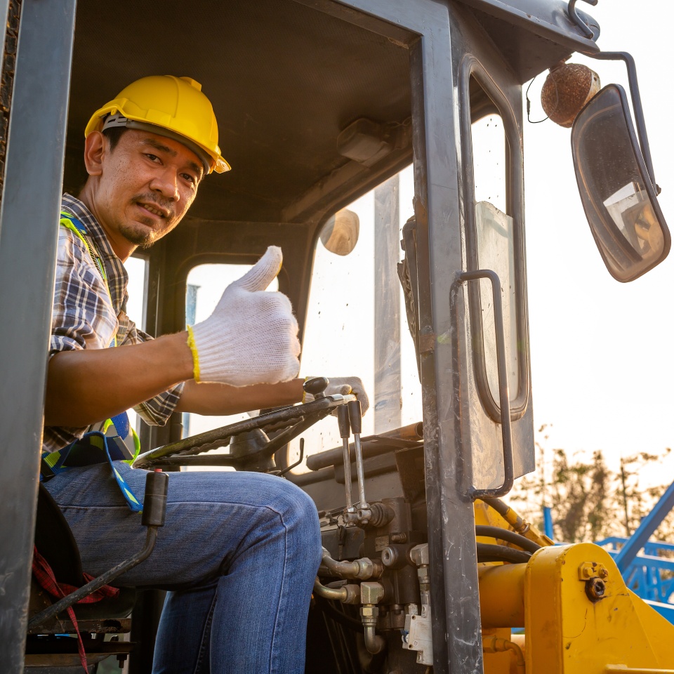 Driving worker heavy wheeled tractor, Wheel loader Excavator with backhoe unloading sand works in construction site.