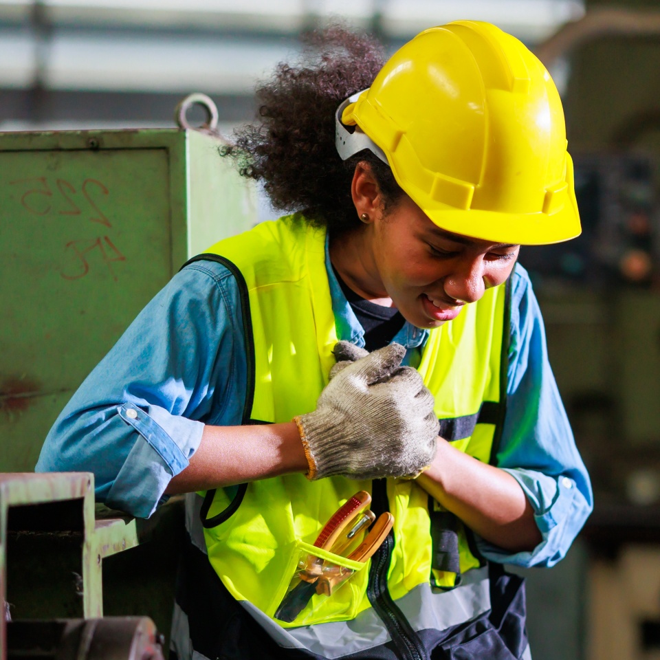 Heart attack concept. Black engineer woman suffering from chest pain at old factory. Metal lathe industrial manufacturing factory