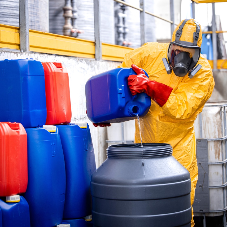 Professional chemicals industry worker in protective equipment making acids for zinc galvanizing.