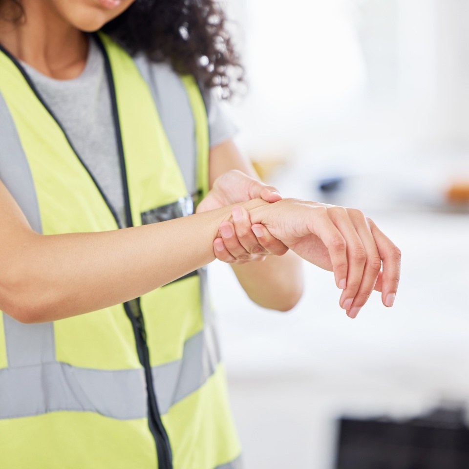 Construction, DIY and wrist pain with woman in home for decoration, design or renovation closeup. Accident, emergency and injury with person in apartment for building, maintenance or remodel